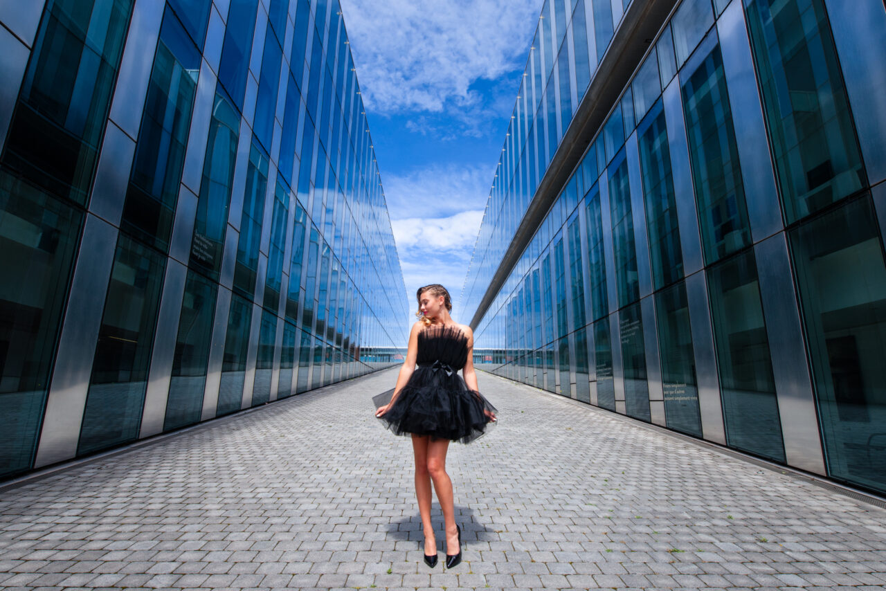 photo de mode en extérieur avec vitrage et reflet robe noire et perspective ligne de fuite